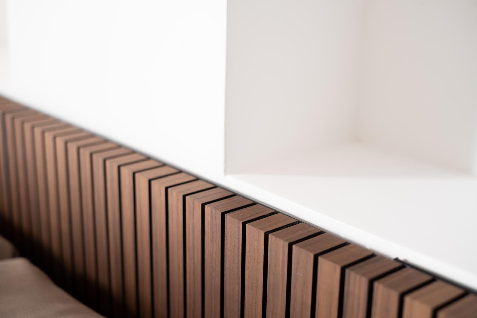 A white shelf with a wooden panel design.