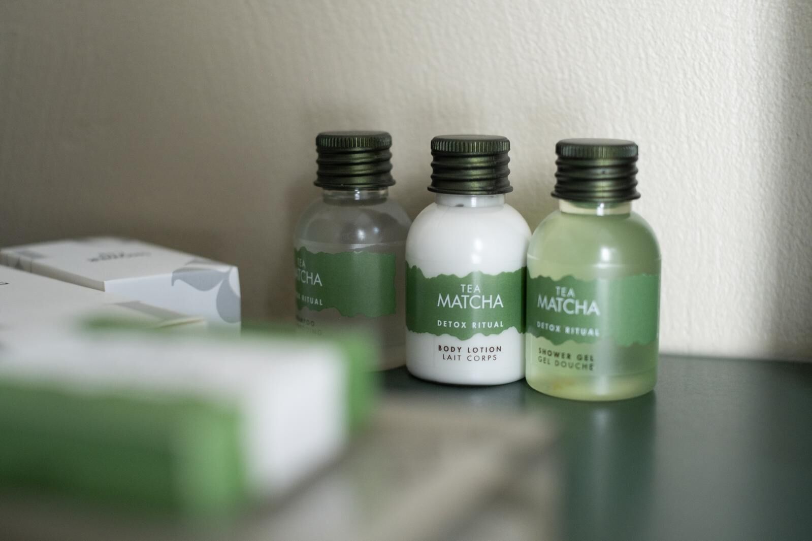 Three bottles of Tea Matcha body lotion, one bottle of Tea Matcha shower gel, and a box of Tea Matcha on a table.