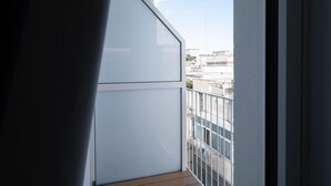 Een balkon met uitzicht op gebouwen en een heldere lucht.