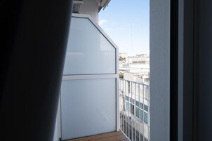 A balcony with a view of buildings and a clear sky.