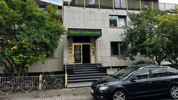 A modern building with a sign reading "Hotel Grünewald" at the entrance. - Hotel Grünewald chs (Hannover)