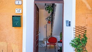 A hotel entrance with a red chair, potted plants, and a staircase. - Camaiore - Cozy Home Between Alps and Sea for Families and Groups (Camaiore)