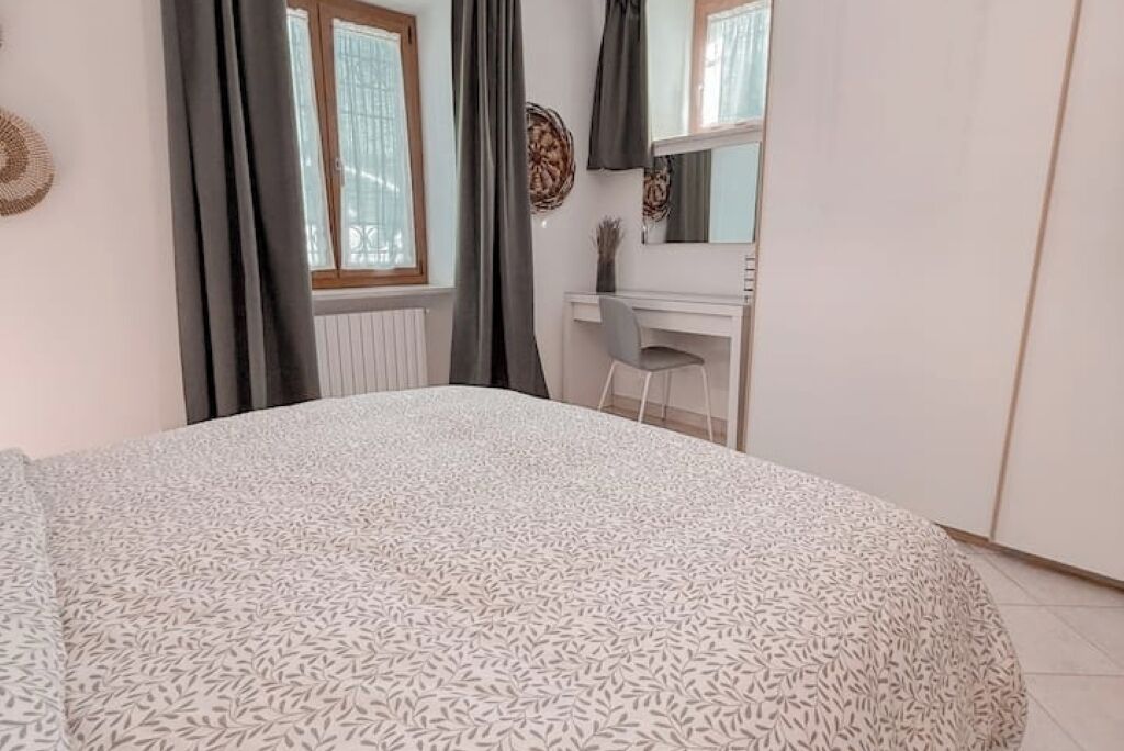 A bedroom with a bed, a desk, and a chair.