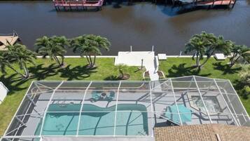 A rooftop pool with a view of a river and palm trees.