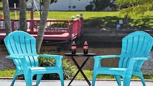Two turquoise Adirondack chairs and a small round table with two bottles of Coca-Cola. - Coral Sunshine - large south terrace with pool/spa (Cape Coral)