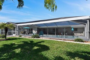 Un espace extérieur abrité avec une piscine, des sièges et un ciel dégagé.