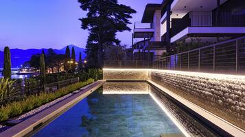 En säsongsöppen utomhuspool och solstolar