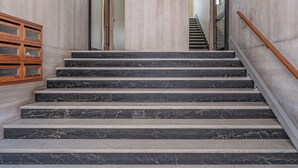 A set of marble stairs with a wooden handrail and a wooden cabinet on the left. - Alta Marea Apulia sea view (Bari)