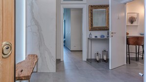 A modern interior with a marble wall, a wooden bench, a mirror, and a bar area. - Alta Marea Apulia sea view (Bari)