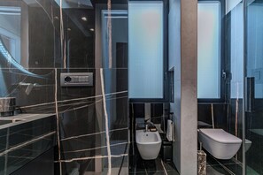 A modern bathroom with a bidet, a toilet, and a bathtub. - Alta Marea Apulia—Sea View   (Bari)