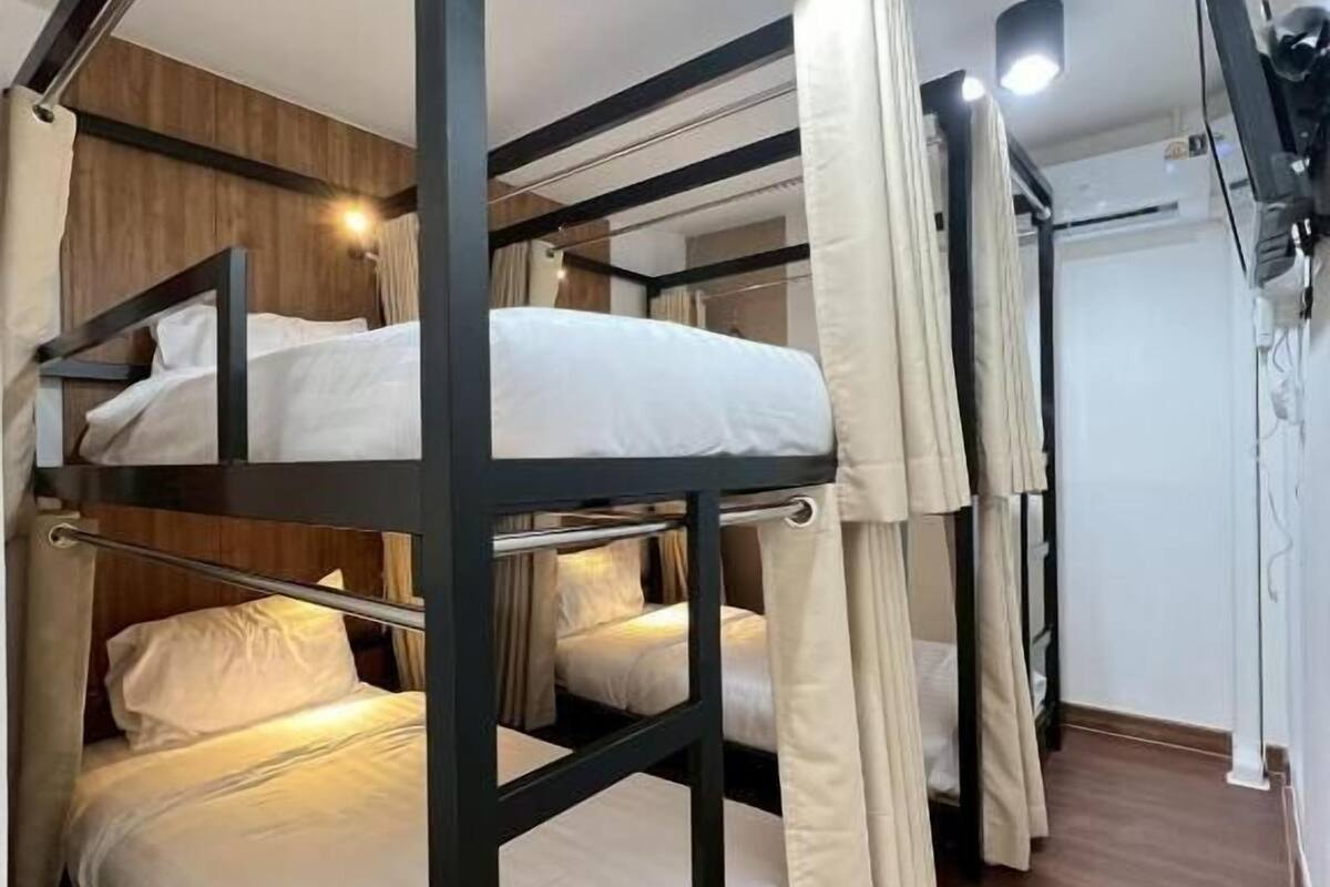 Dormitorio con literas, paredes de madera y una lámpara en el techo.