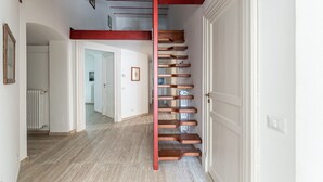 Eine Treppe mit roter Handläufe, die zu einer oberen Etage führt.