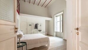 Ein Schlafzimmer mit einem Bett, einem Nachttisch, einem Kleiderschrank und einem Fenster.