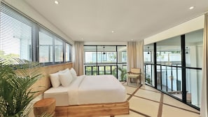 A modern bedroom with a large bed, a wooden headboard, and a view of a balcony. - Spacious 7-bedroom villa in Canggu: Private chef, Pool, Movie theater (Badung)