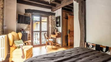 A bedroom with a bed, a chair, a desk, and a television.