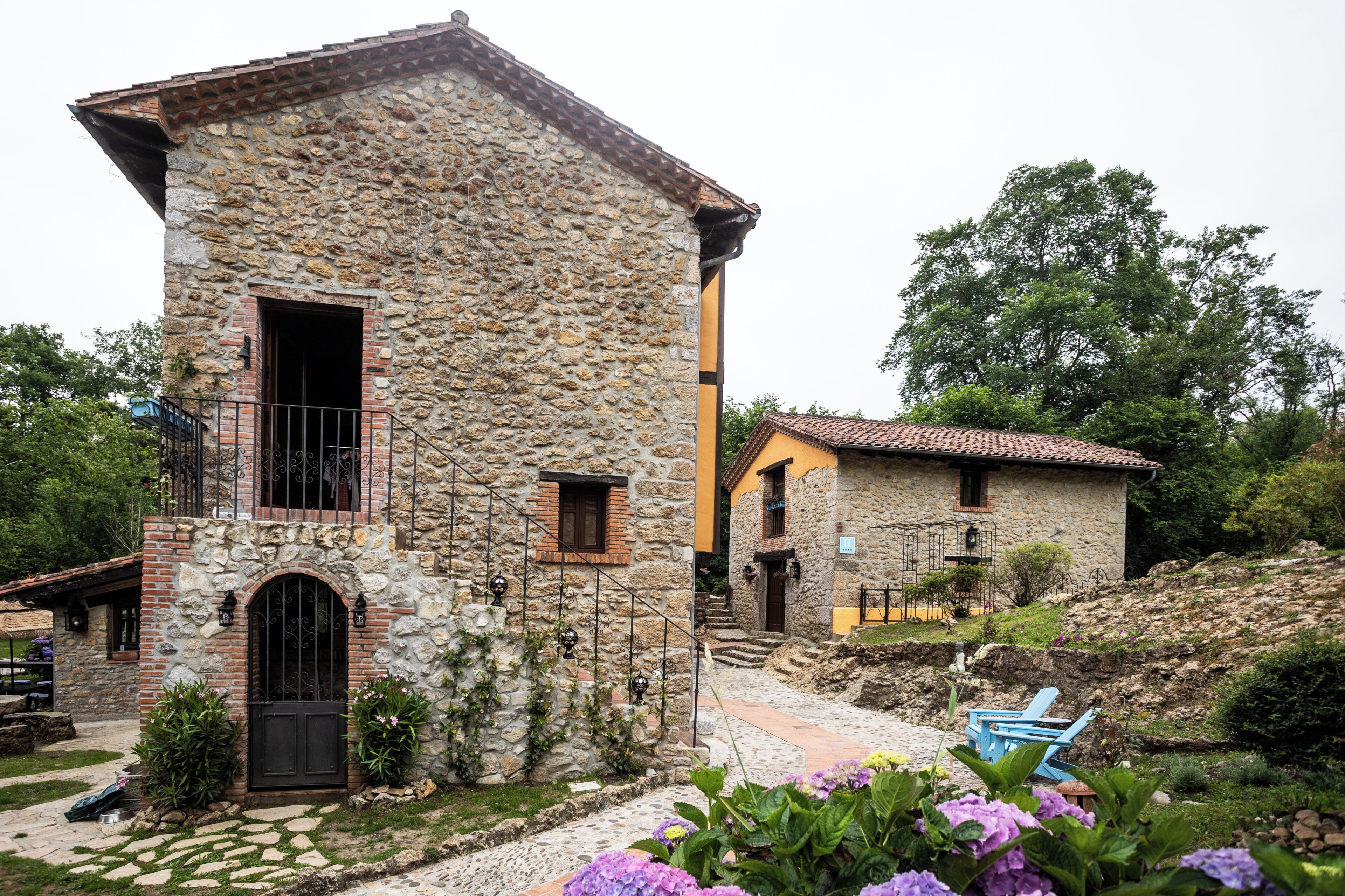 A stone building with a balcony, a door, and a window.