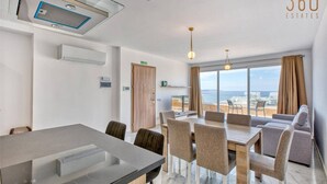 A modern kitchen with a large island, a dining area with a view, and a seating area with a view of the sea. - Penthouse Paradise in Qawra opposite the beach ! (St. Paul`s Bay)