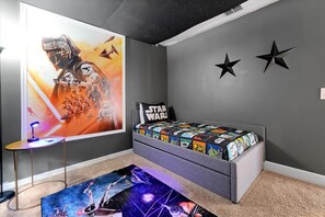 A bedroom with a Star Wars themed bedspread, a Star Wars poster on the wall, and a Star Wars themed rug. - Family-Friendly 6BR Villa w/ Pool, Game Room (Kissimmee)