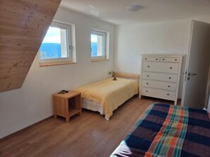 A bedroom with a bed, a dresser, a nightstand, and two windows. - Apartment 'Schwarzwaldblick Brünlisbach Adler & Kuckuck' (Hochschwarzwald Card incl.) (Grafenhausen)