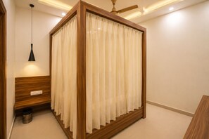 Una habitación con una cama de estructura de madera, una lámpara colgante y un ventilador de techo.