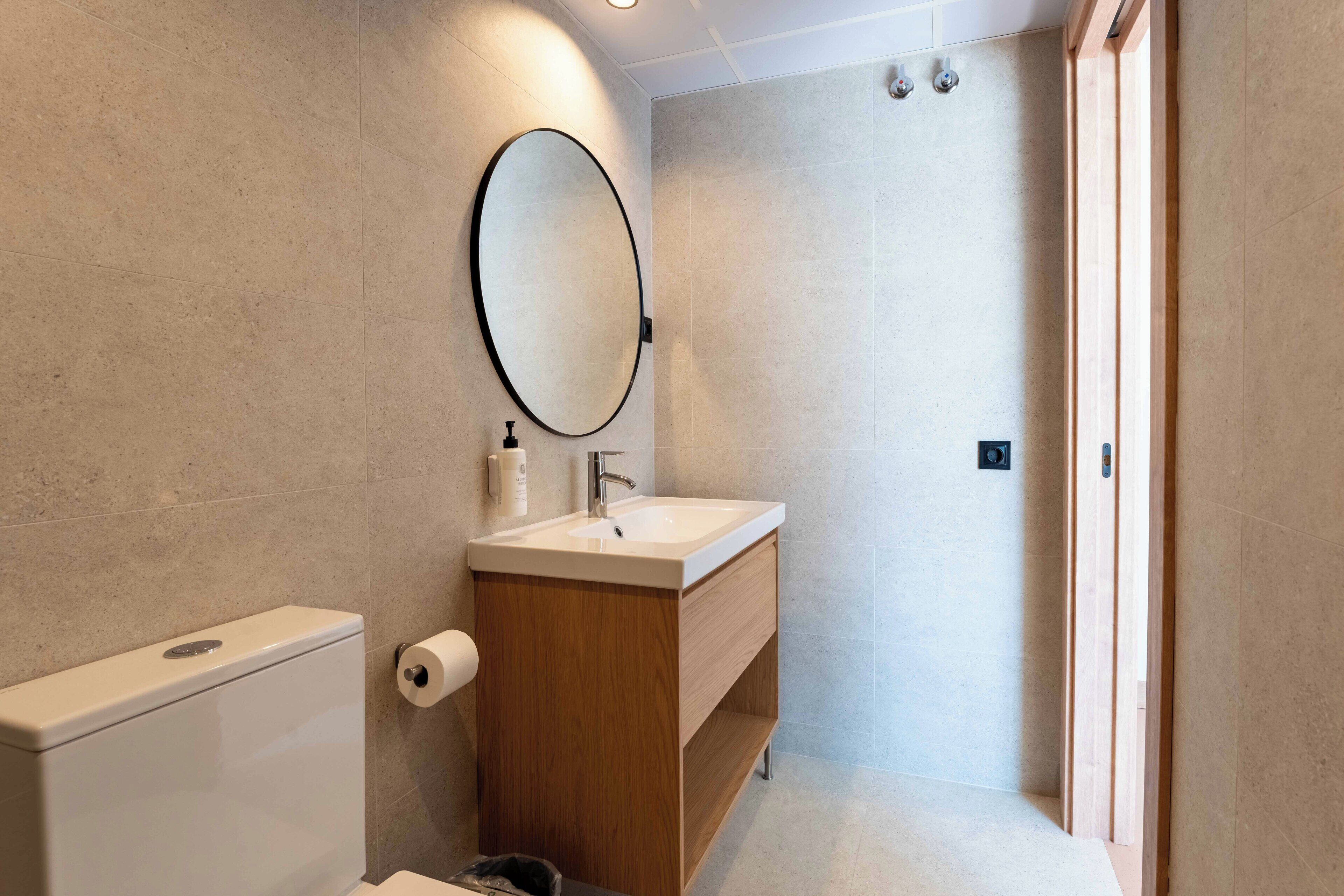 Un bagno moderno con servizi igienici, lavandino e specchio.