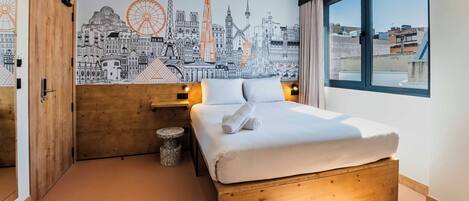 A bedroom with a cityscape mural, a wooden bed, bedside lamps, and a window with a view.