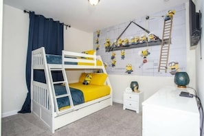 A bunk bed with a desk and a shelf with minion decorations. - Astonishing Home Private Pool 4830 (Kissimmee)