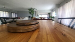 Uma área de refeições com uma mesa de madeira, cadeiras e um ventilador de teto.