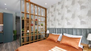 A modern bedroom with a large bed, a built-in wooden shelving unit, and a grey textured wall. - The NEO two room Suite N302 by MaRKoS (Gudauri)