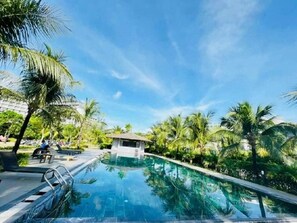 A swimming pool with clear blue water, surrounded by palm trees and a small pavilion. - MT Luxury Villas Bai Truong Phu Quoc (Phu Quoc)