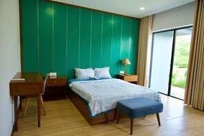 Ein modernes Schlafzimmer mit einem großen Bett, einem Schreibtisch und einem Fenster mit Vorhängen.