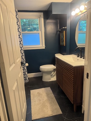 Een badkamer met toilet, wastafel en douche.