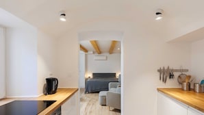 Una cocina moderna con tope de inducción negro, armarios de madera y encimera.