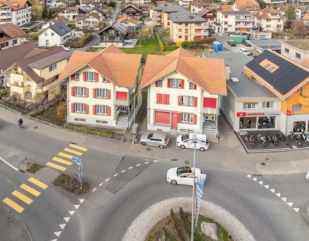 Un quartier résidentiel avec des maisons, une concessionnaire Honda et un rond-point.