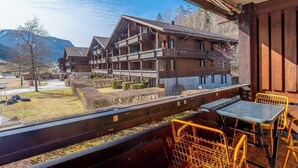 Un chalet en bois doté d’un balcon donnant sur un paysage montagneux.
