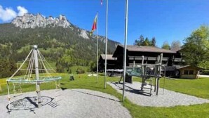 Une vue sur la montagne avec un chalet, une balançoire et un télescope.