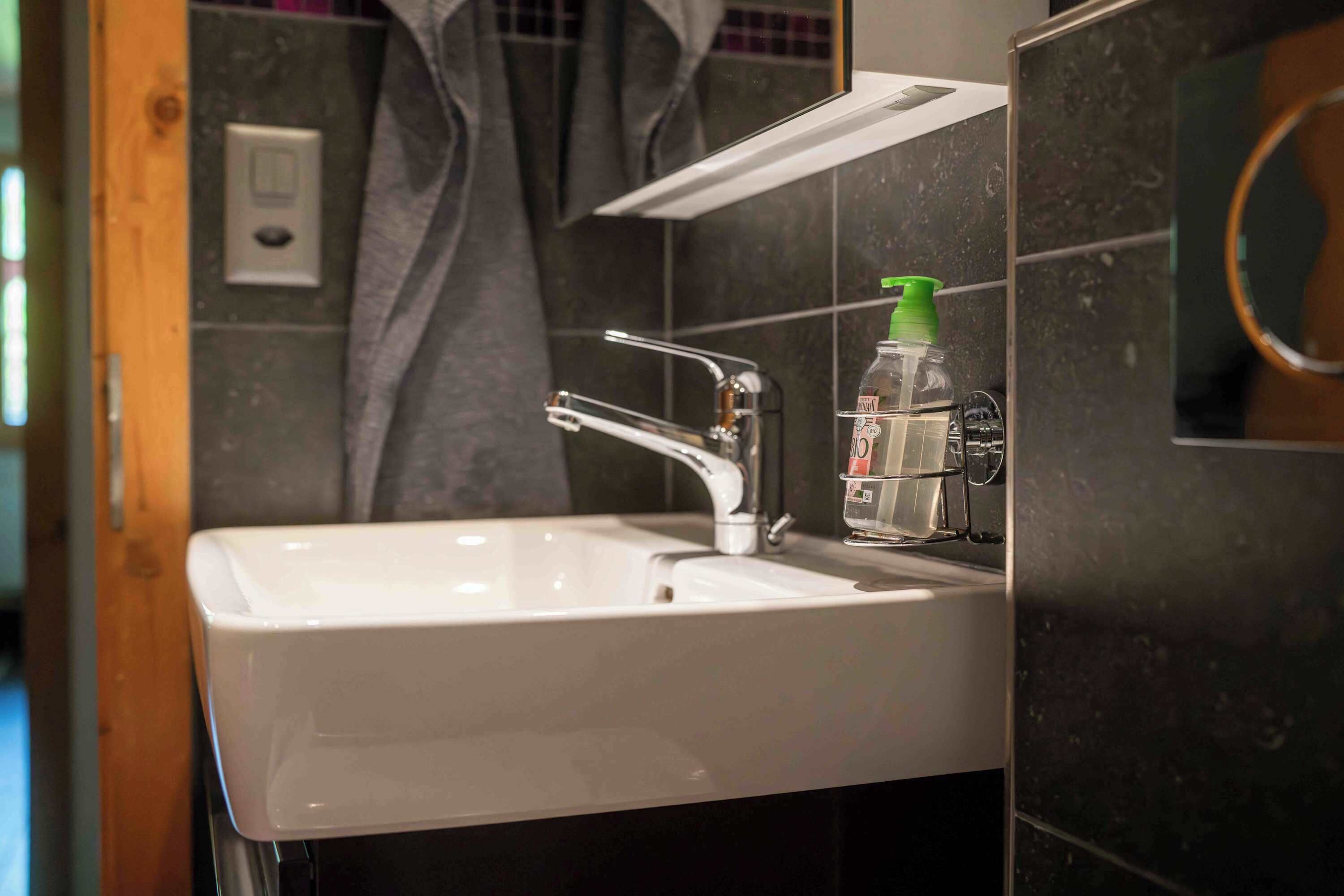 Ein Badezimmer mit Waschbecken, Spiegel und Handtuchhalter.
