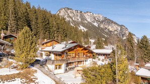 A wooden lodge with a balcony and a mountain backdrop. - With Hot Tub, Sauna, Garden|with View near Gondola (Diemtigen)