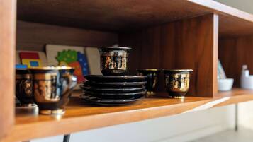 A wooden shelf with black and gold decorative items, including bowls and a small vase.