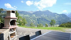Una parrilla de piedra con vista a las montañas.