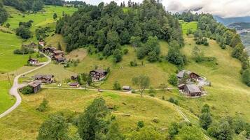Een landelijk dorp met traditionele houten huizen, een kronkelende weg en weelderige groene velden.