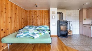 Una habitación con cama, chimenea y una zona de cocina.