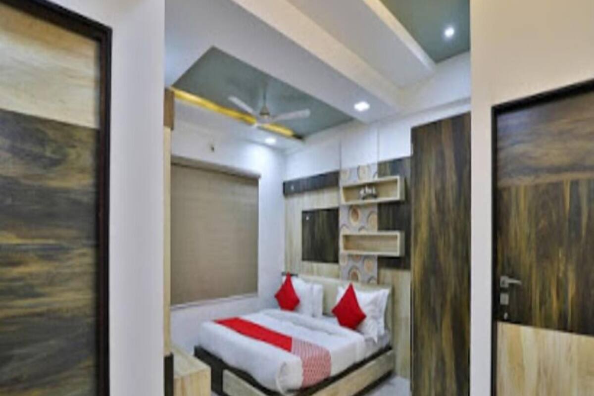 A bedroom with a bed, a ceiling fan, and wooden doors.