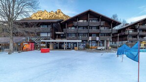 Ein mehrstöckiges Hotel mit Holzfassade, großen Fenstern und Balkonen.