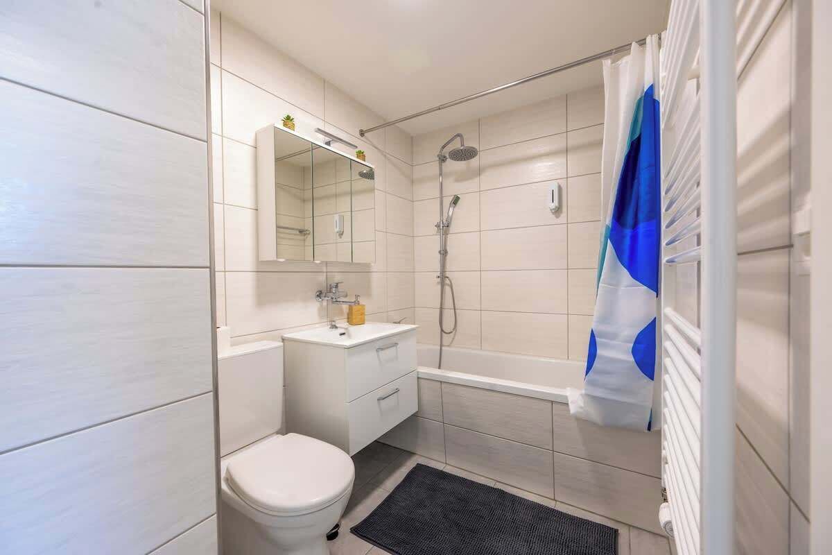 Une salle de bain moderne équipée d’une douche, de toilettes et d’un lavabo.