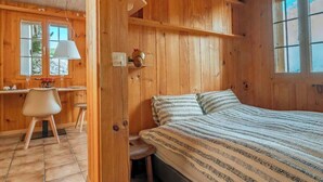 A wooden cabin with a bed, a desk, and a chair. - Lake and Mountain View Chalet,Fireplace and Garden (Axalp)