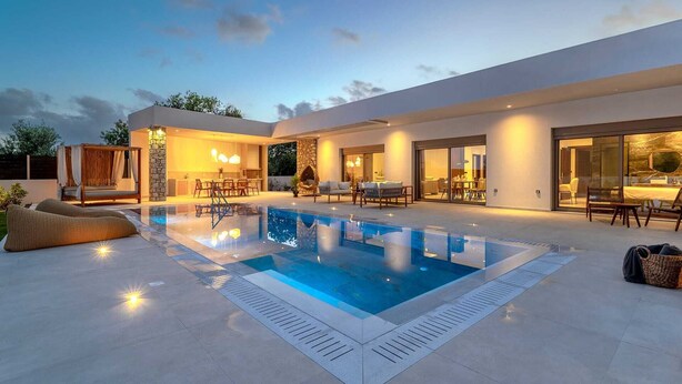 A modern house with a swimming pool, outdoor seating, and a well-lit patio area. - Welcome to Ruby Paradise, a luxurious villa nestled in thearea of Sgourou. (Sgourou)