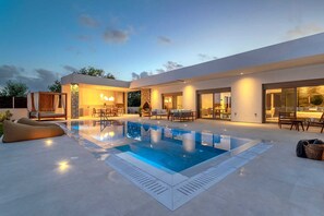A modern house with a swimming pool, outdoor seating, and a well-lit patio area. - Welcome to Ruby Paradise, a luxurious villa nestled in thearea of Sgourou. (Sgourou)