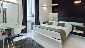 A modern hotel room with a large bed, bedside tables, a desk with a chair, a mirror, and a window with curtains. - Navona to Stay (Rome)