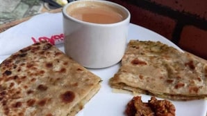 A plate with two pieces of flatbread and a cup of tea. - Kashiyana Stay (Varanasi)